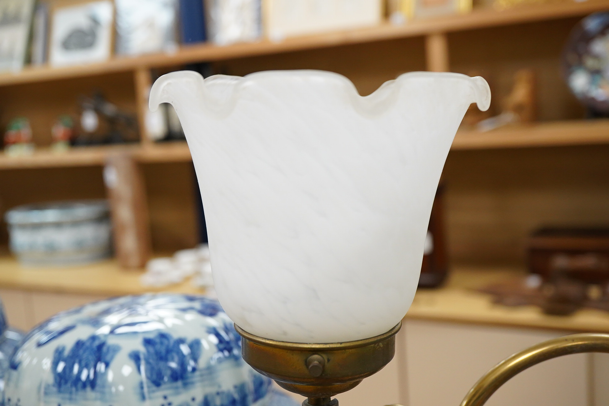 A brass rise and fall table lamp with opaque glass shades, 60cm high when extended